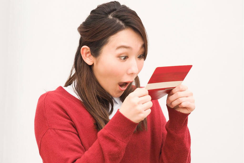 通帳を見て驚いている女性の写真