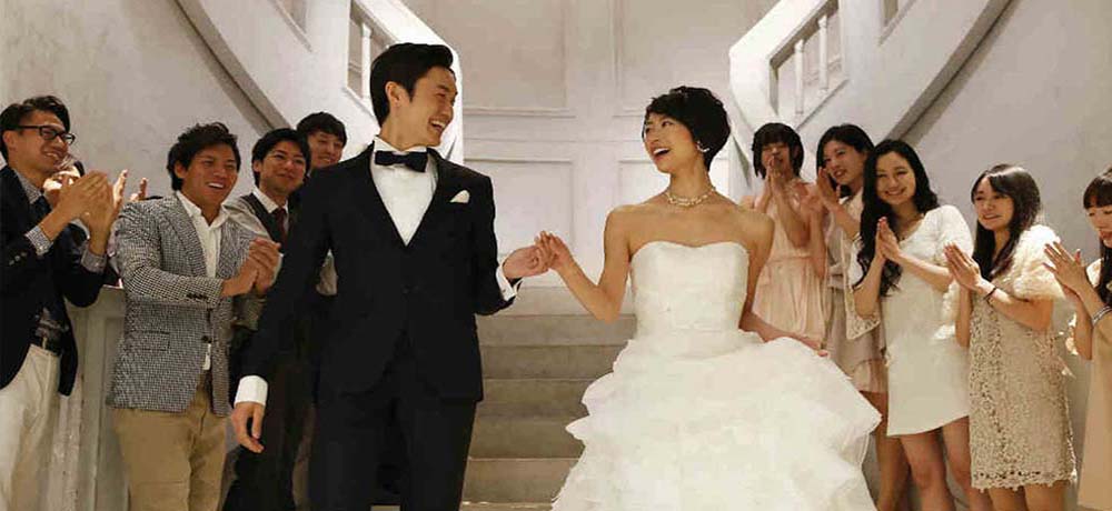 手を繋いで会談を降りる新郎新婦の写真