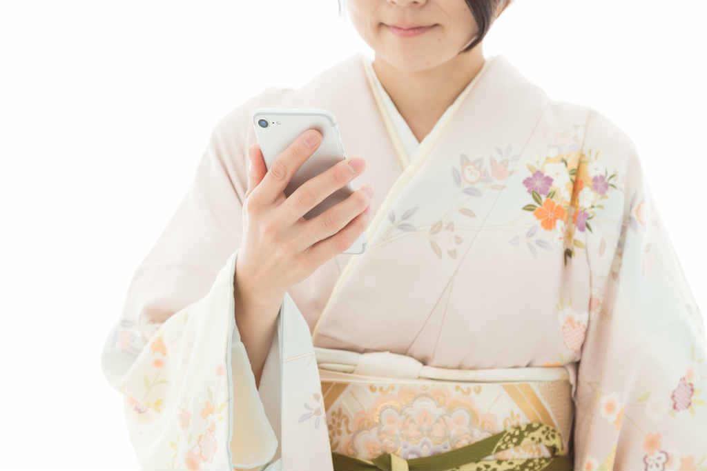 着物姿でスマホを見る女性の写真