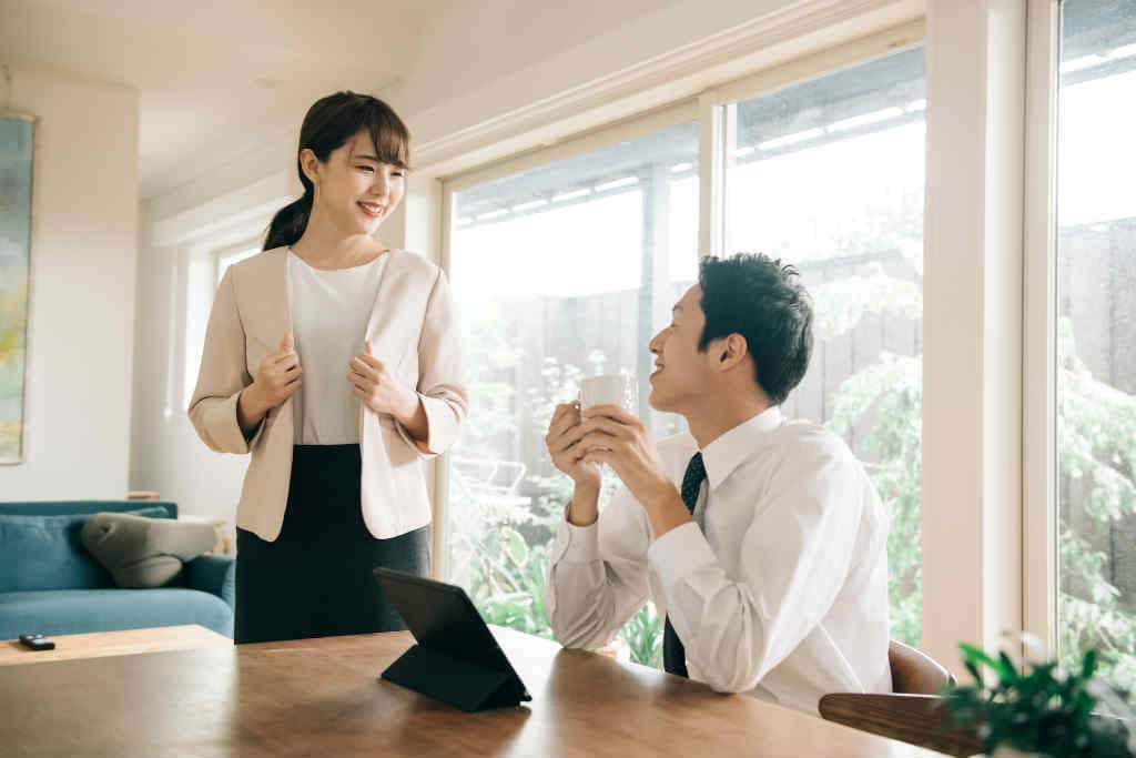 朝の食卓で会話をする夫婦の写真