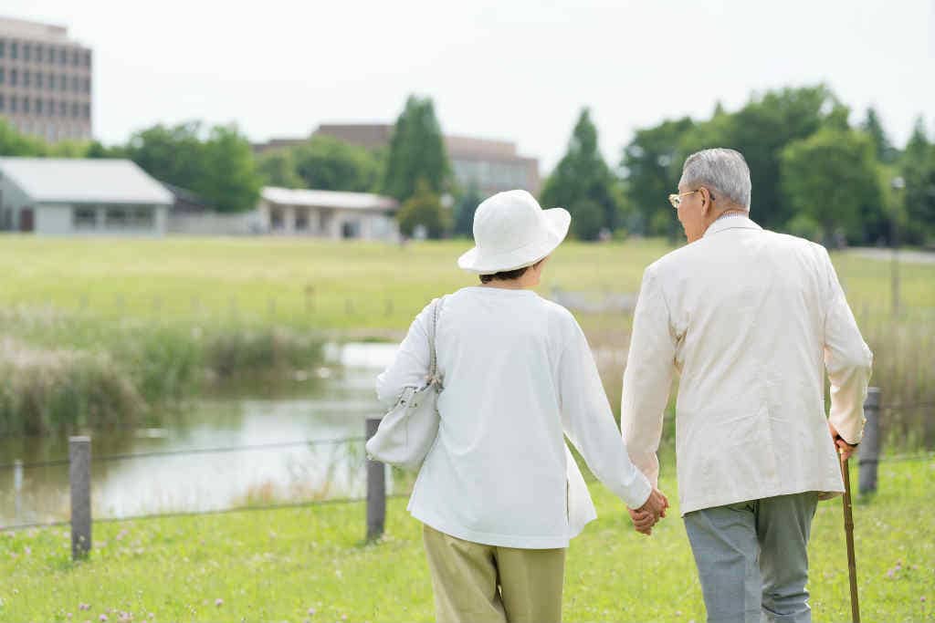 手を繋いで散歩している老夫婦の写真