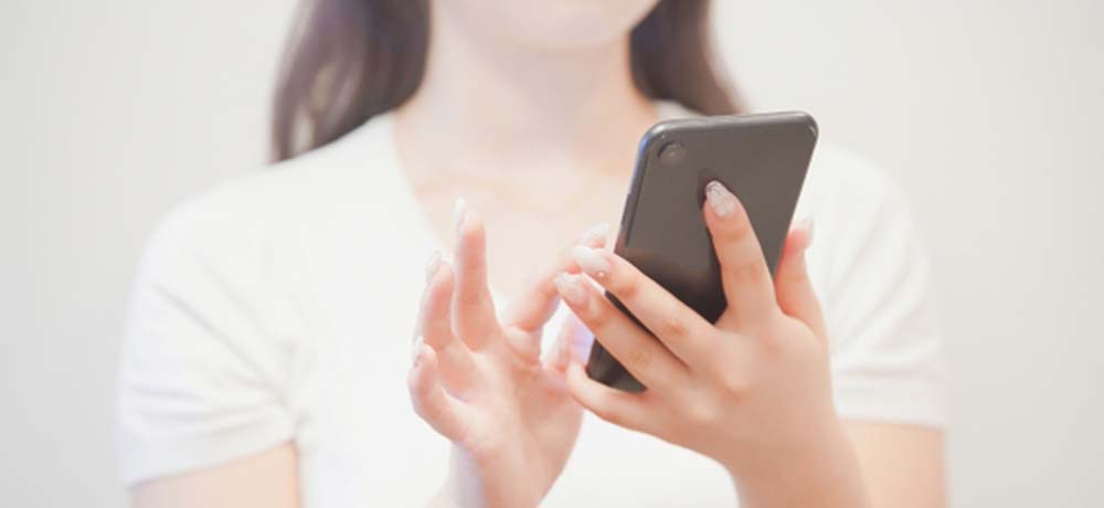 スマホを見る女性の写真