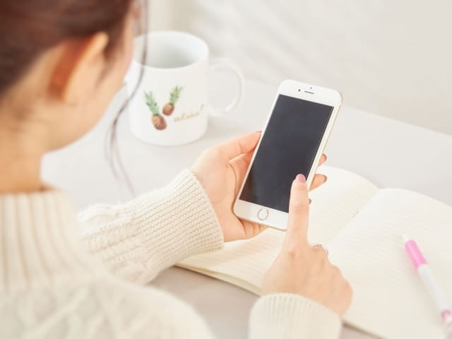 スマホを操作する女性の写真