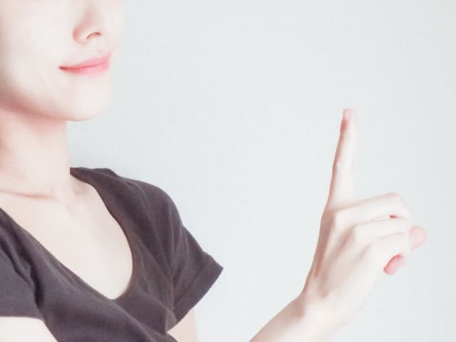 人差し指を立てる女性の写真