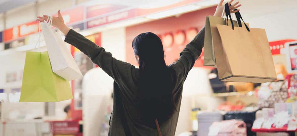 紙の買い物袋をたくさん持つ女性の写真